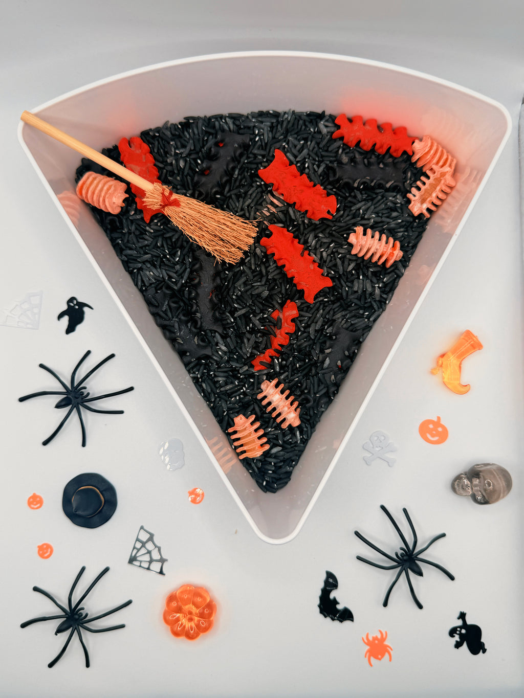 Zombie Bones Halloween sensory play mix with black coloured rice, bone pasta and spooky loose parts for sensory bins.