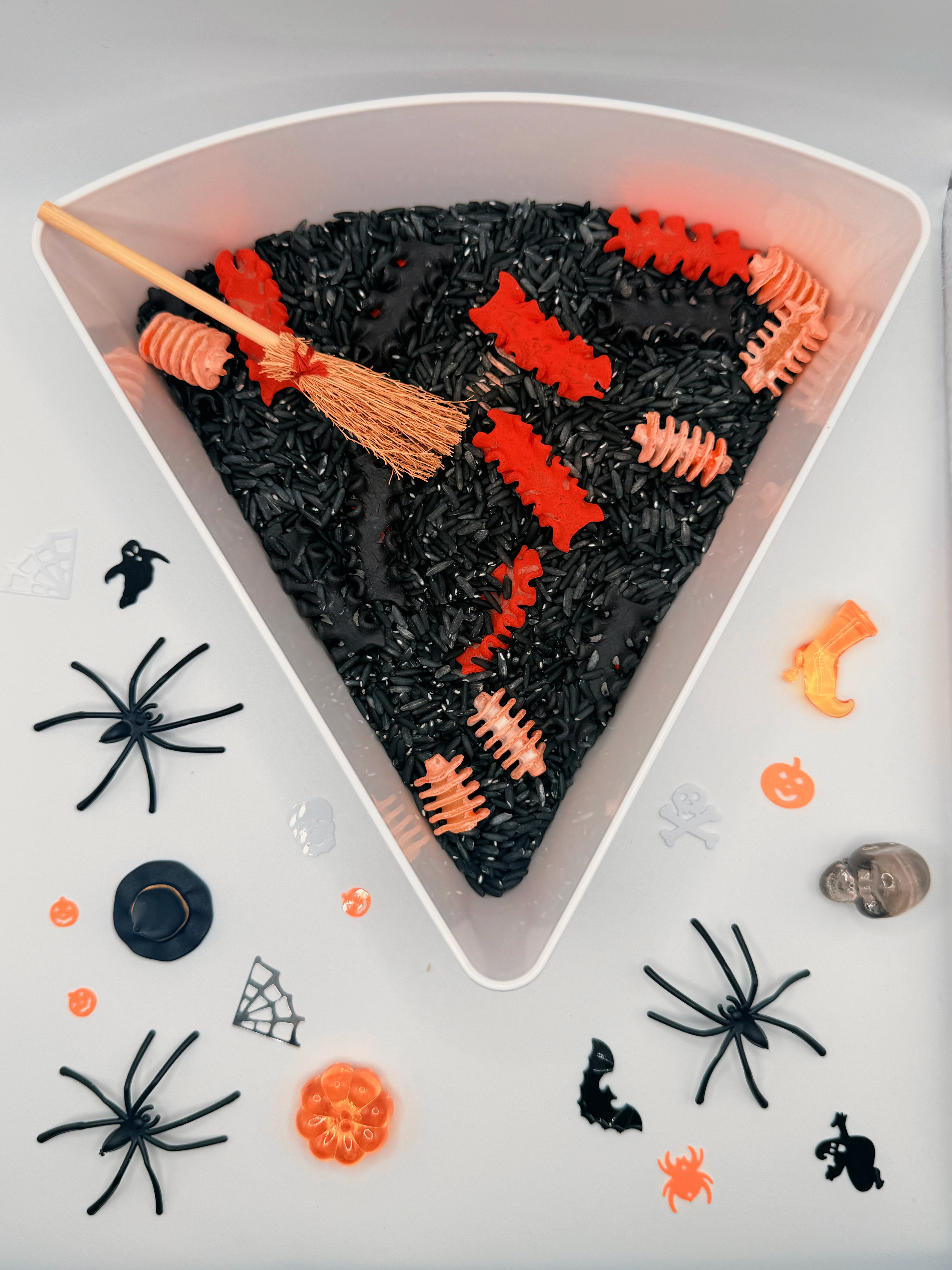 Zombie Bones Halloween sensory play mix with black coloured rice, bone pasta and spooky loose parts for sensory bins.